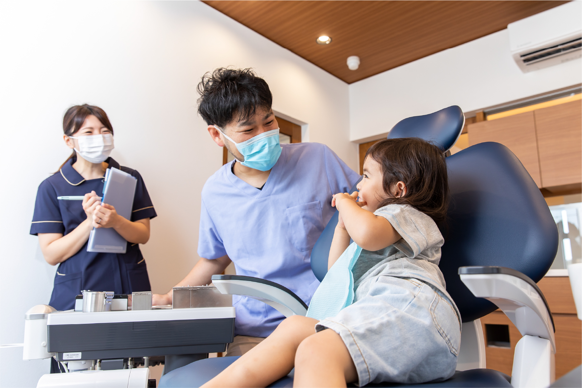 笑顔で手を繋いで寝そべるご家族